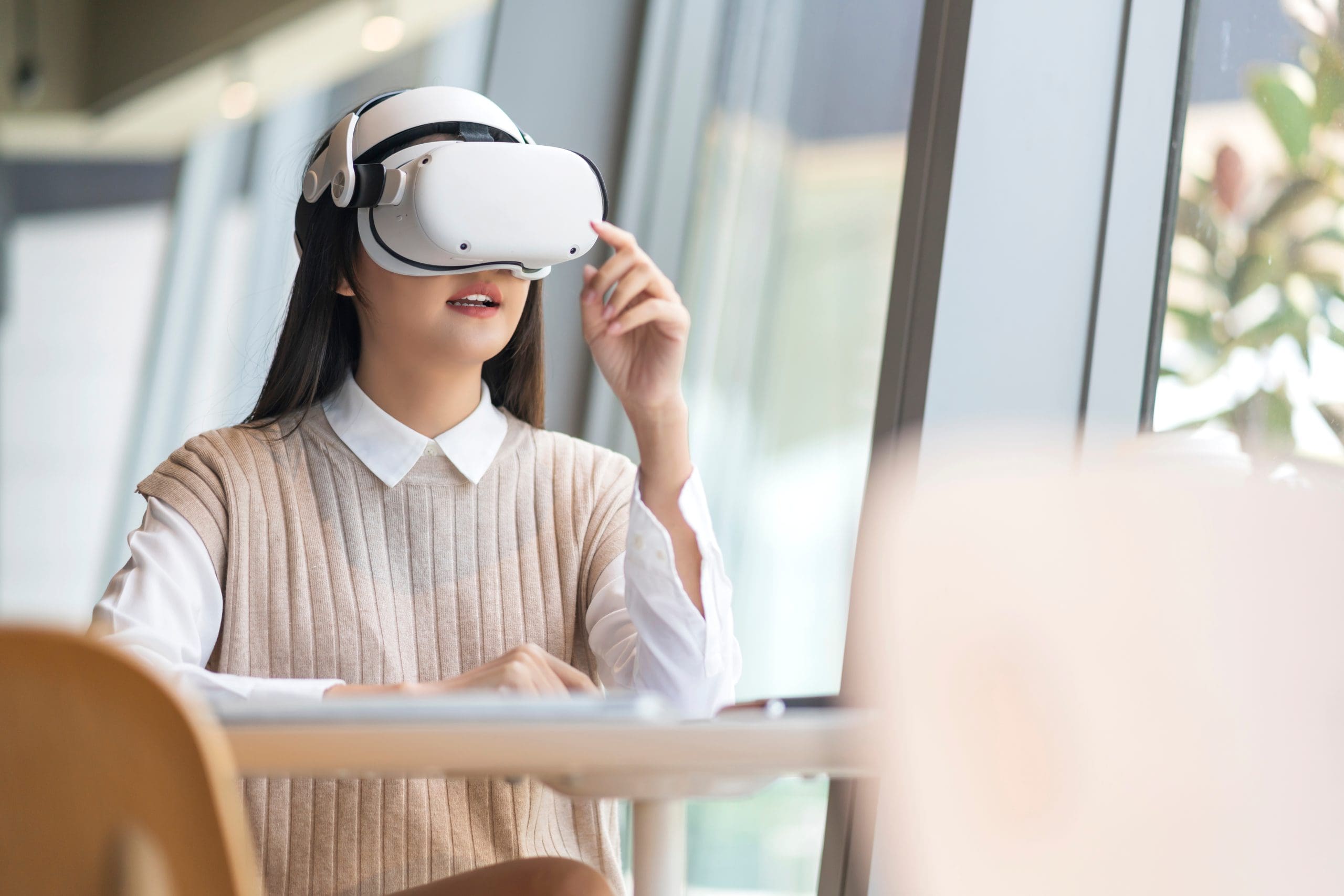 smart attractive asian female business owner weared virtual reality glasses enjoys casual metaverse meeting with concentrate at cafe restaurant,asian female using oculus rift headset in cafe